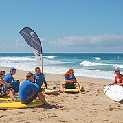 surfinstruktören Peter förklarar surfbrädan surfcoach Peter visar hur surfbrädan fungerar under introduktionen på stranden