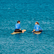 vänter på den perfekta vågen surfkursdeltagare sitter på brädan och väntar på rätt våg ute i line-upen