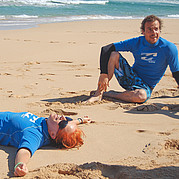 trött men lycklig efter en dag med surf surfkursdeltagare ler utmattad efter en intensiv dag med surfing och sol