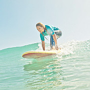 take-off på en grön våg surfare reser sig på brädan och fångar en ren, grön våg under en lektion